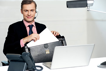 Image showing Male call centre executive arranging paper works