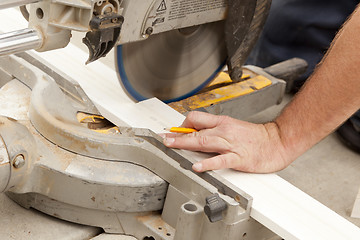 Image showing Contractor Cutting New Baseboard for Renovation