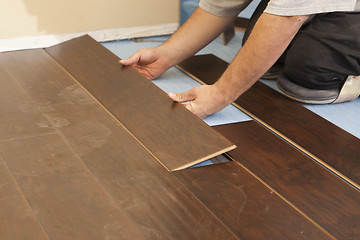 Image showing Man Installing New Laminate Wood Flooring