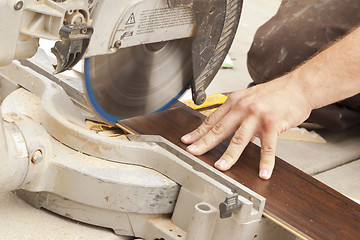 Image showing Contractor Using Circular Saw Cutting of New Laminate Flooring