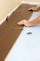 Image showing Man Installing New Laminate Wood Flooring