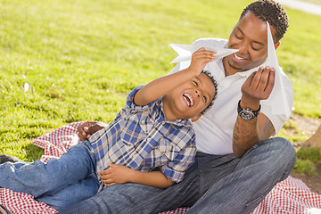 Image showing Mixed Race Father and Son Playing with Paper Airplanes