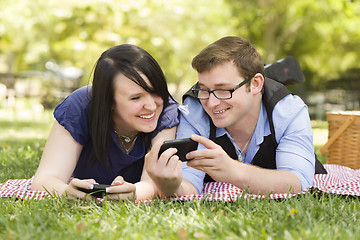 Image showing Young Couple at Park Texting Together