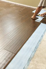 Image showing Man Installing New Laminate Wood Flooring