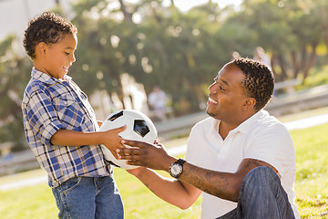 Image showing Father Hands New Soccer Ball to Mixed Race Son