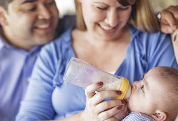 Image showing Happy Mixed Race Couple Bottle Feeding Their Son