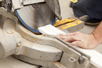 Image showing Contractor Cutting New Baseboard for Renovation