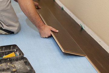 Image showing Man Installing New Laminate Wood Flooring