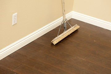 Image showing Push Broom on a Newly Installed Laminate Floor and Baseboard