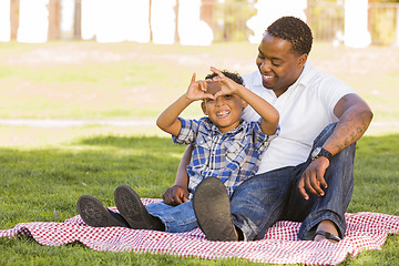 Image showing Mixed Race Father and Son Making Heart Hand Sign