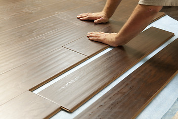 Image showing Man Installing New Laminate Wood Flooring