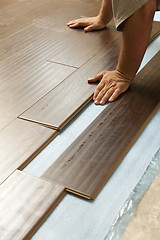 Image showing Man Installing New Laminate Wood Flooring