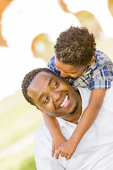 Image showing Mixed Race Father and Son Playing Piggyback in Park