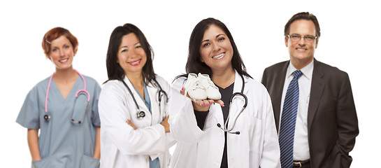 Image showing Hispanic Female Doctor or Nurse with Baby Shoes and Support Staf