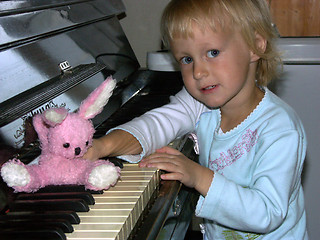 Image showing Playing the piano with a toy