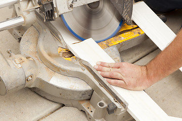 Image showing Contractor Cutting New Baseboard for Renovation