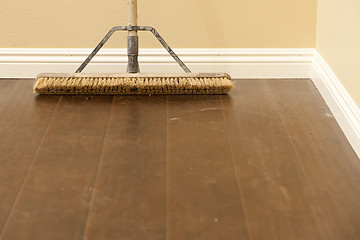 Image showing Push Broom on a Newly Installed Laminate Floor and Baseboard