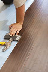 Image showing Man Installing New Laminate Wood Flooring