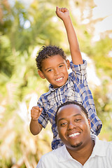 Image showing Mixed Race Father and Son Cheering with Fist in Air