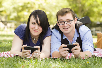 Image showing Young Couple at Park Texting Together