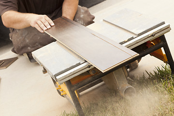 Image showing Contractor Using Circular Saw Cutting of New Laminate Flooring