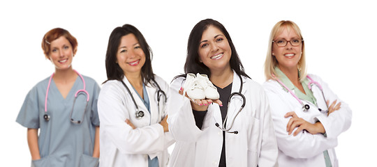Image showing Hispanic Female Doctor or Nurse with Baby Shoes and Support Staf
