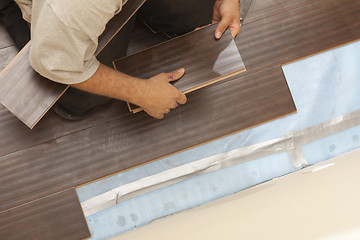 Image showing Man Installing New Laminate Wood Flooring