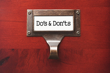 Image showing Lustrous Wooden Cabinet with Do's and Don'ts File Label