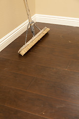 Image showing Push Broom on a Newly Installed Laminate Floor and Baseboard