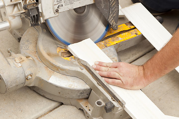 Image showing Contractor Cutting New Baseboard for Renovation