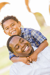 Image showing Mixed Race Father and Son Playing Piggyback in Park