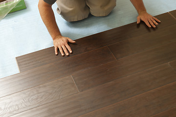 Image showing Man Installing New Laminate Wood Flooring