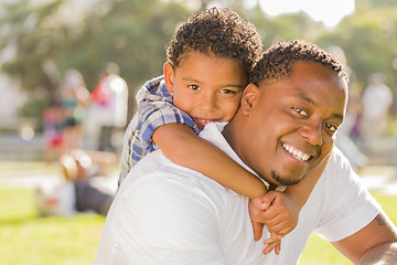 Image showing Mixed Race Father and Son Playing Piggyback in Park