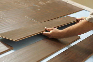 Image showing Man Installing New Laminate Wood Flooring