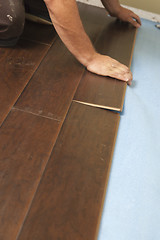 Image showing Man Installing New Laminate Wood Flooring