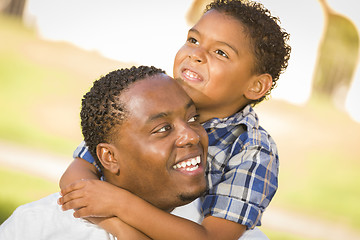 Image showing Mixed Race Father and Son Playing Piggyback in Park