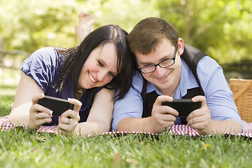 Image showing Young Couple at Park Texting Together