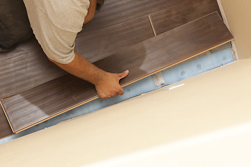 Image showing Man Installing New Laminate Wood Flooring