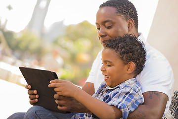 Image showing Mixed Race Father and Son Using Touch Pad Computer Tablet