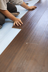 Image showing Man Installing New Laminate Wood Flooring