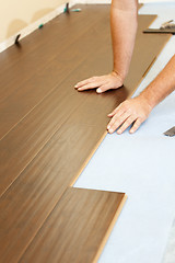 Image showing Man Installing New Laminate Wood Flooring