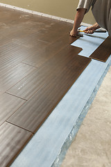 Image showing Man Installing New Laminate Wood Flooring