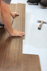 Image showing Man Installing New Laminate Wood Flooring