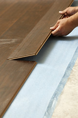 Image showing Man Installing New Laminate Wood Flooring