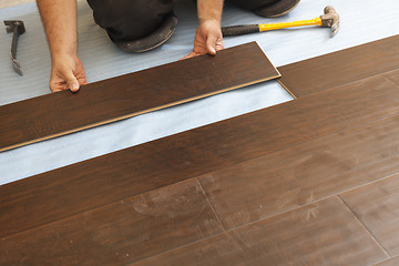 Image showing Man Installing New Laminate Wood Flooring