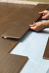 Image showing Man Installing New Laminate Wood Flooring