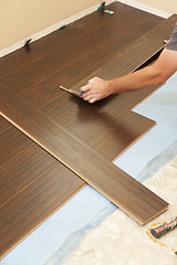 Image showing Man Installing New Laminate Wood Flooring