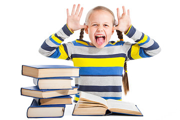 Image showing schoolgirl with books putting out the tongue on isolated white