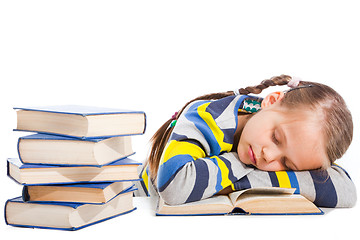 Image showing schoolgirl  sleeping over the book on isolated white