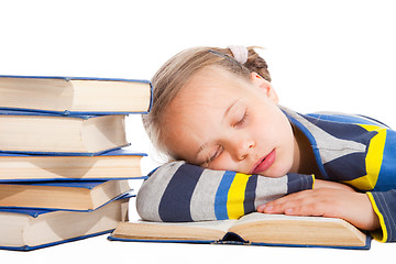 Image showing schoolgirl  sleeping over the book on isolated white